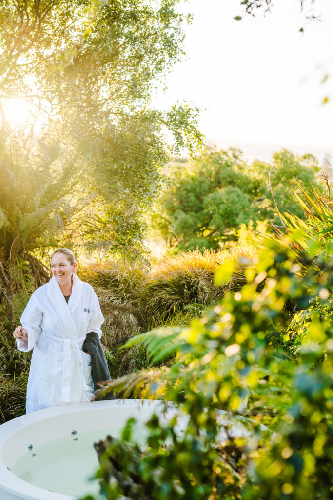 Lady enjoying a lakeside spa bath at Eagles Nest Retreat best spa accommodation in Tasmania